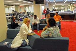 Students sitting in the learning commons chatting.